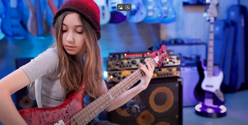 EllenPlaysBass in action on her hugely successful YouTube channel, with the Gravity Stands Neckhug Glow Stand in the background.