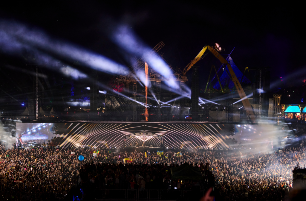 Cameo Light ZENIT W300 Wash Lights on Main Stage Tomorrowland 2025 with light beams and the Ruins of burnt stage in the background