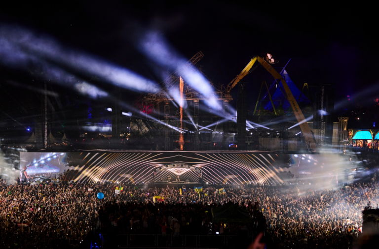 Cameo Light ZENIT W300 Wash Lights on Main Stage Tomorrowland 2025 with light beams and the Ruins of burnt stage in the background